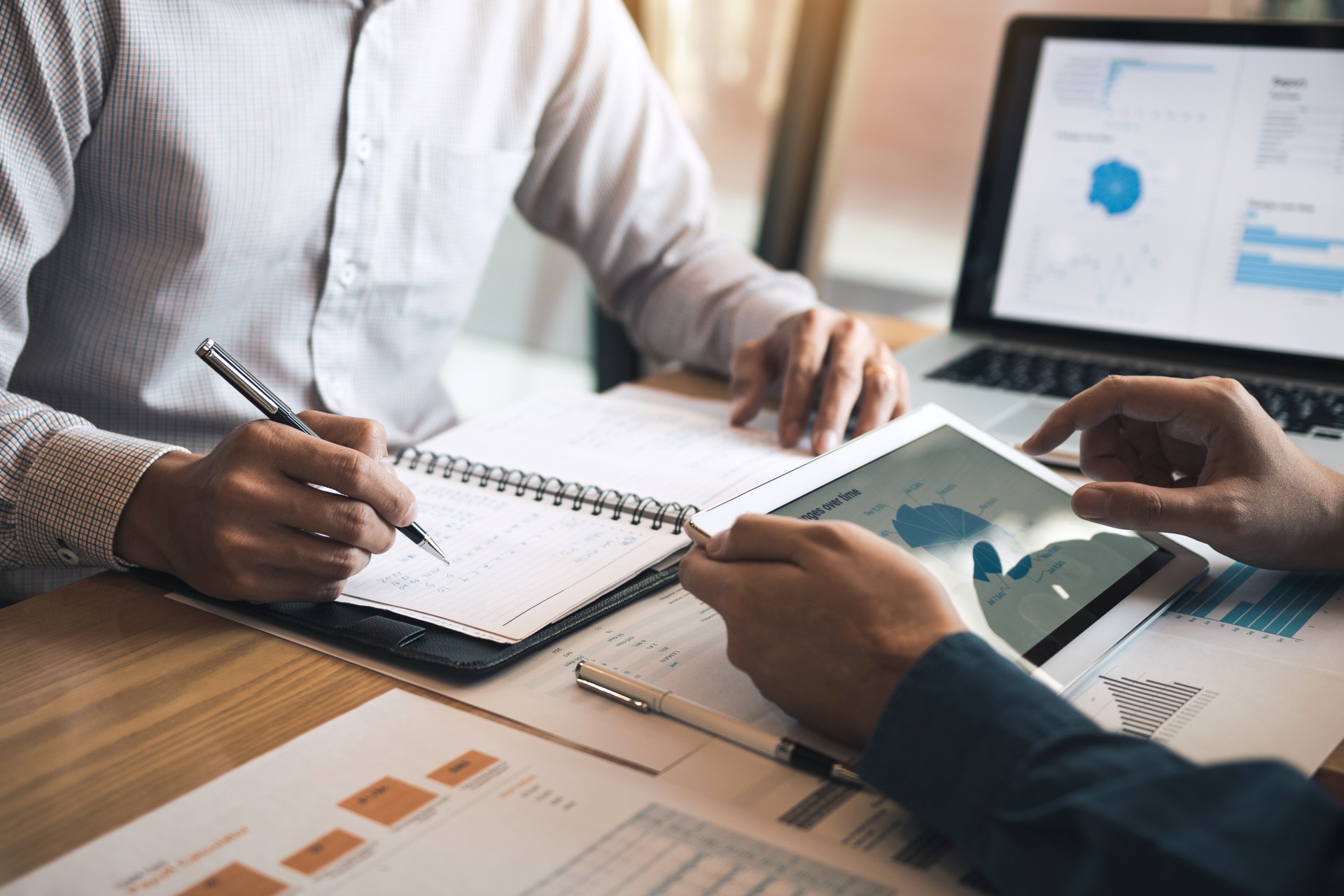 Two business partnership coworkers discussing a financial planning graph and company during a budget meeting in office room.